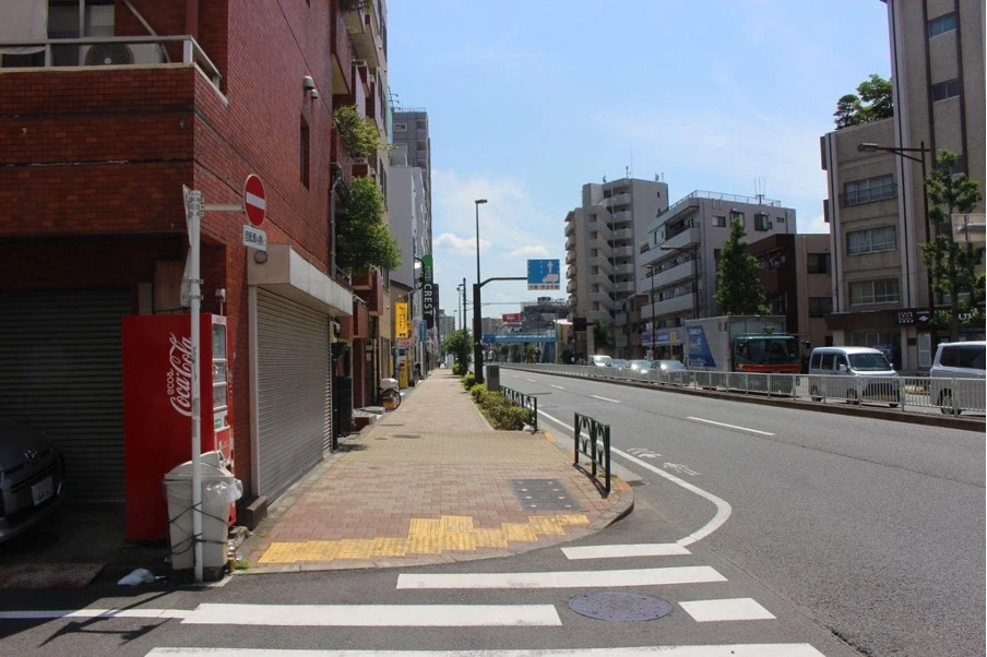 蔵前橋通り沿いにあるオレンジ色のレンガ調の建物。この奥側（2つ目）にパーソナルジム REVOIST 平井蔵前橋通り店があります。