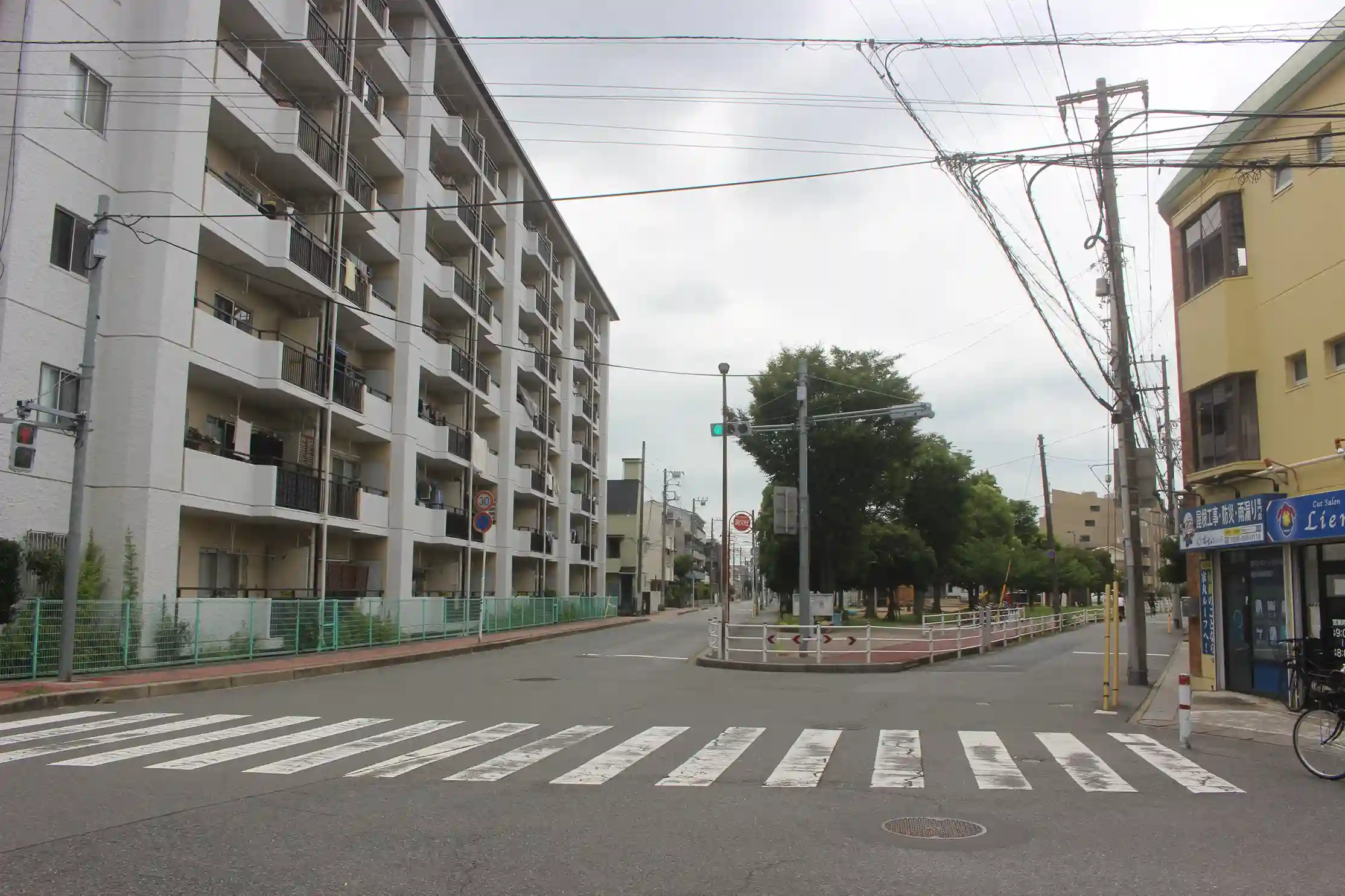 前方に東場（ひがしば）公園の緑が見える5差路の交差点。ここから左方向の道へ進みます。