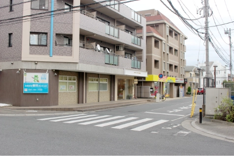 カエルの青い看板の歯科と美容室treatがある道。この建物の道に向かいます。