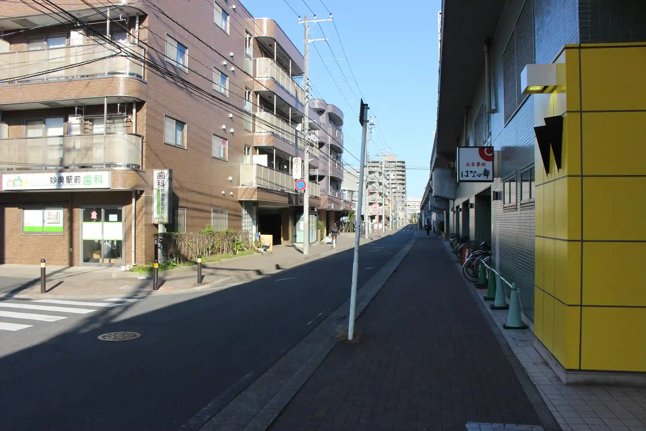 妙典駅の出口から右側へ進む高架線沿いの道。妙典駅前歯科の前を直進します。