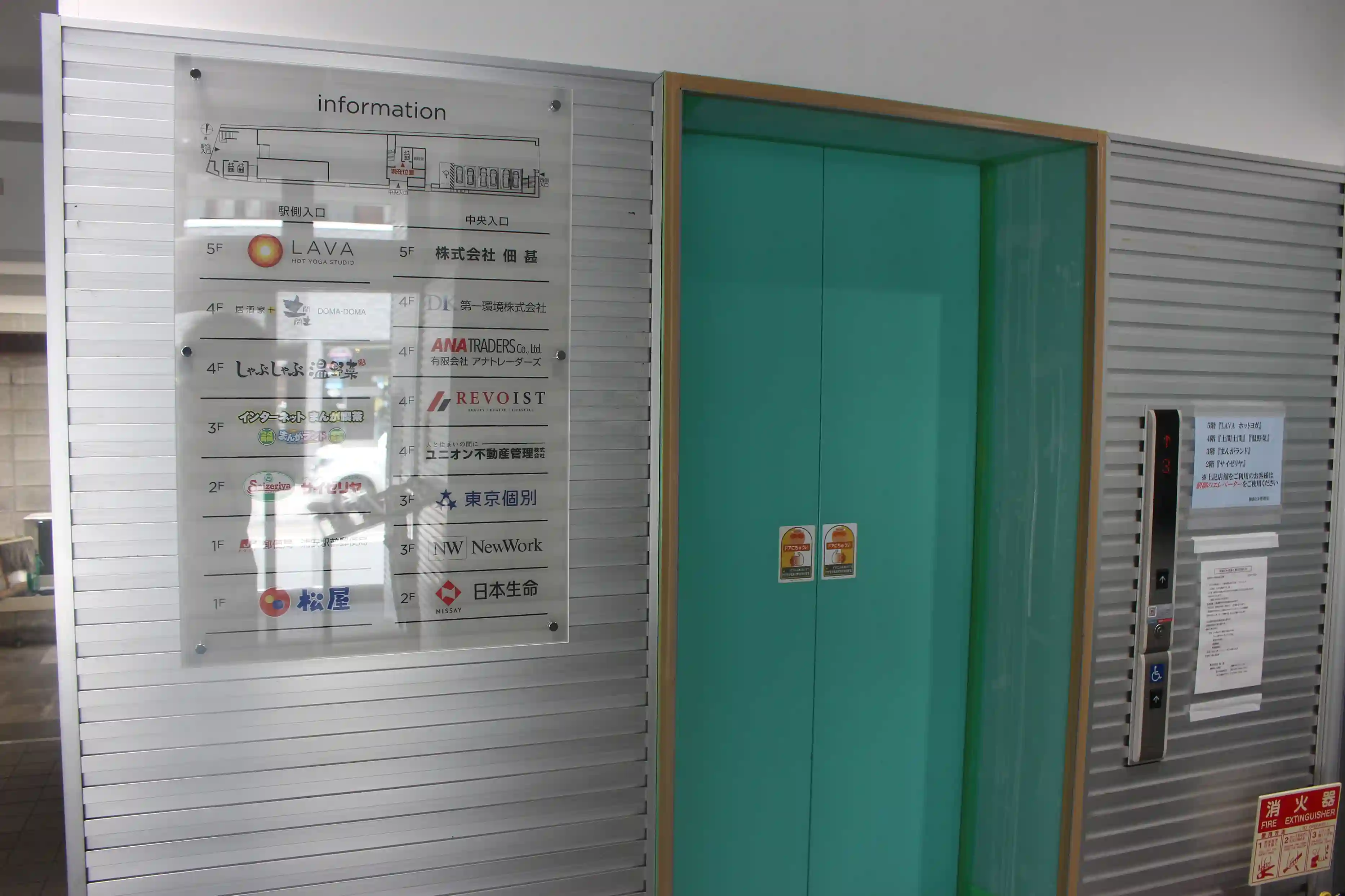 佃基ビル1階のエレベーターホール。こちらの緑色のエレベーターで4階へ上がります。