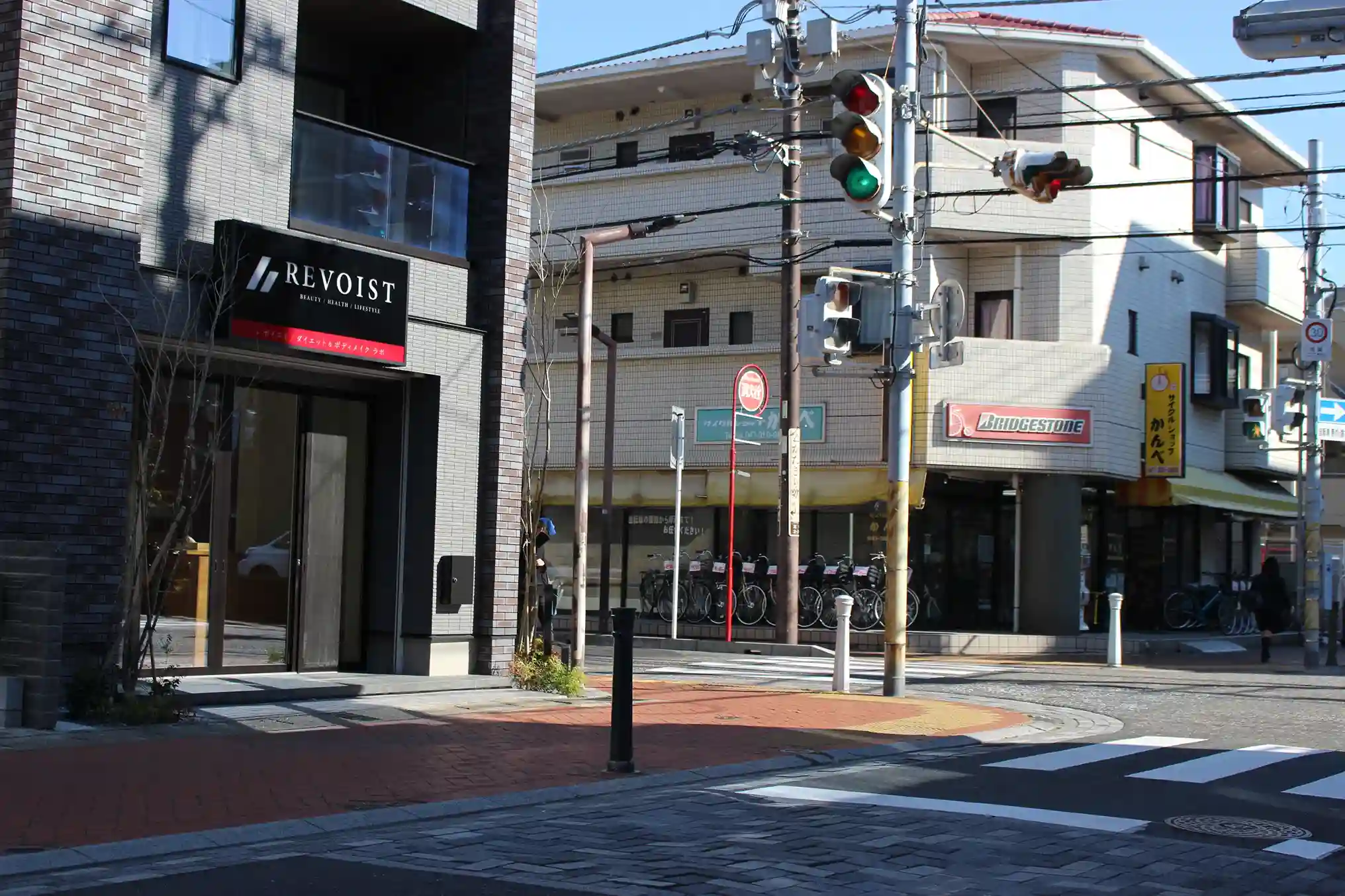 自転車屋（サイクルショップかんべ）がある交差点の左手に見える、パーソナルジム REVOIST 浦安ダイエー前店の外観。