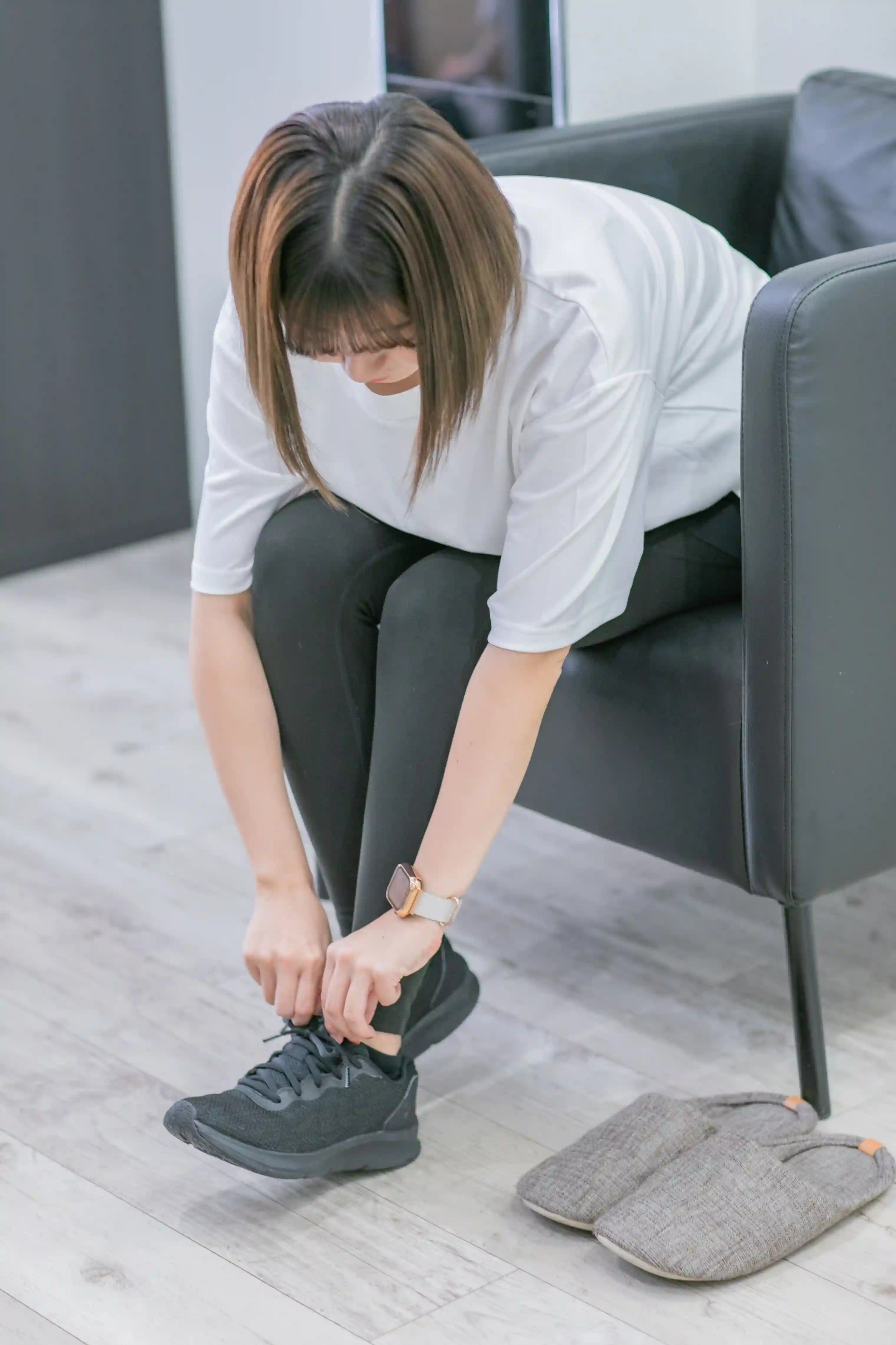 浦安のパーソナルジム「REVOIST」でレンタルシューズを履いて準備をする女性。手ぶらで通えるようシューズの貸し出しも行っており、お着替え後すぐに体験を始められます。