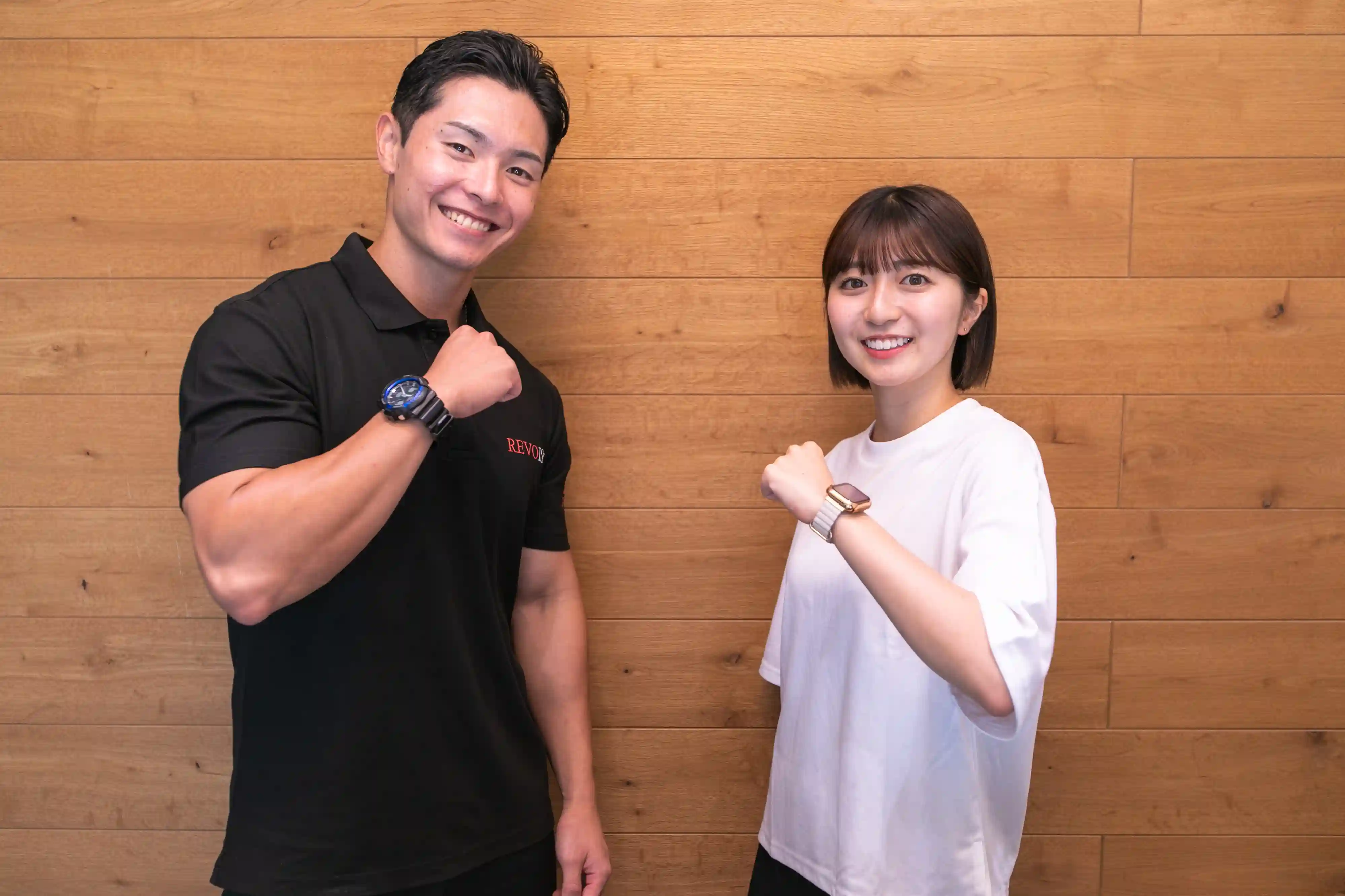 浦安のパーソナルジム「REVOIST」にご入会いただき、トレーナーと笑顔でガッツポーズをする女性。ご納得いただけた場合は、体験当日のご入会手続きもスムーズに行えます。